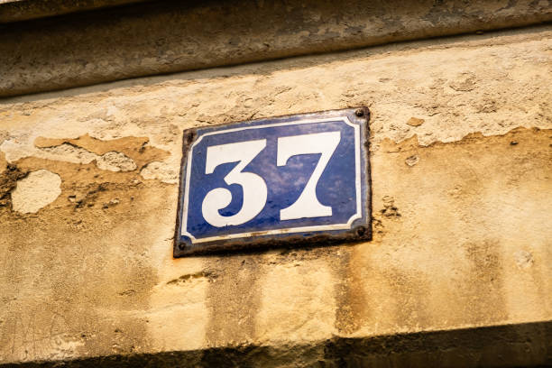 istock Vintage Weathered House Number 37 Plaque on Rustic Wall 2167460320
