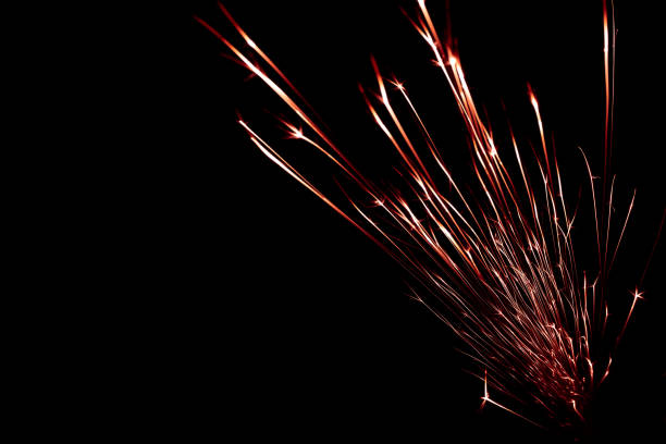 red sparks from the grinder glowing in the dark
