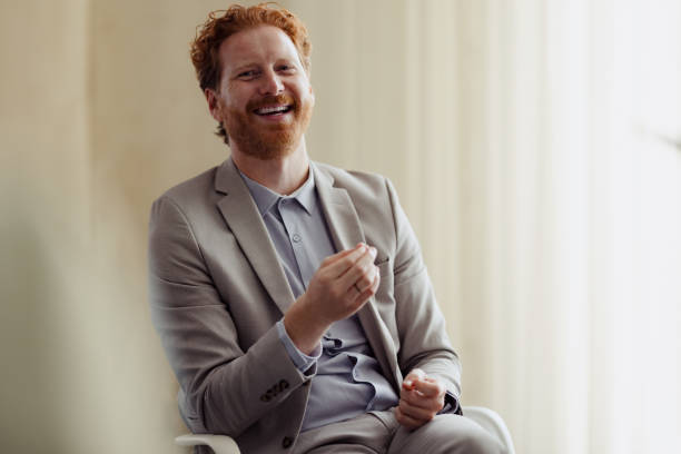 Smiling Businessman in Office Setting Holding Conversation
