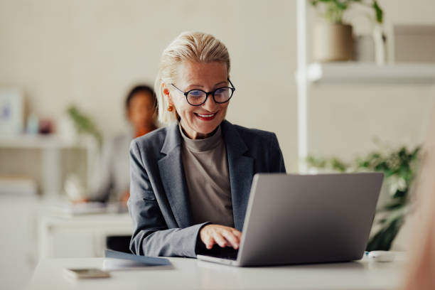 istock Senior Businesswoman Working On Laptop In Modern Office Setting 2167466300