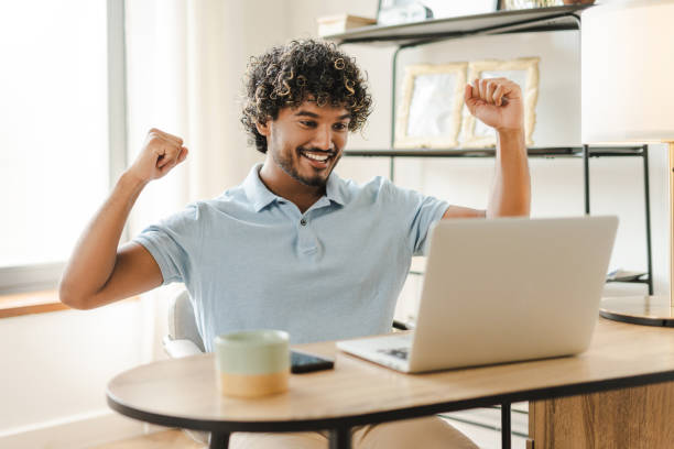 istock Happy young freelancer celebrating success working from home office victory concept 2167466368