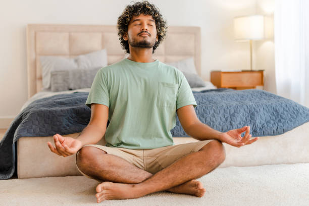 istock Young Indian man practicing meditation at home in the morning 2167466421