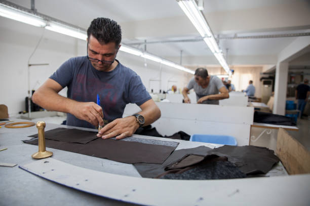 istock Male Worker Sewing Jackets In Leather Workshop Applying Glue With Brush 2167466951