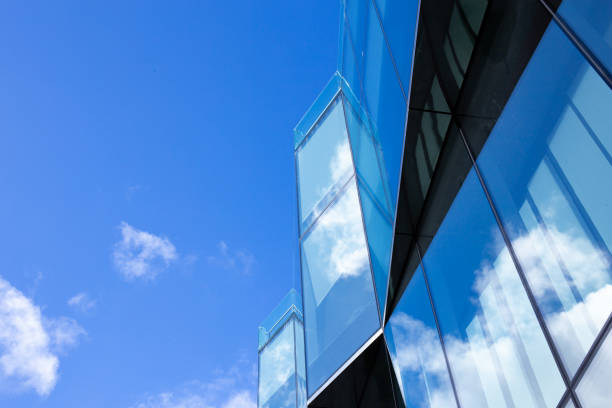 istock Beautiful architecture business office building with window glass pattern in the skyscraper city. Clouds are reflected in the glass facade of the building 2167468555
