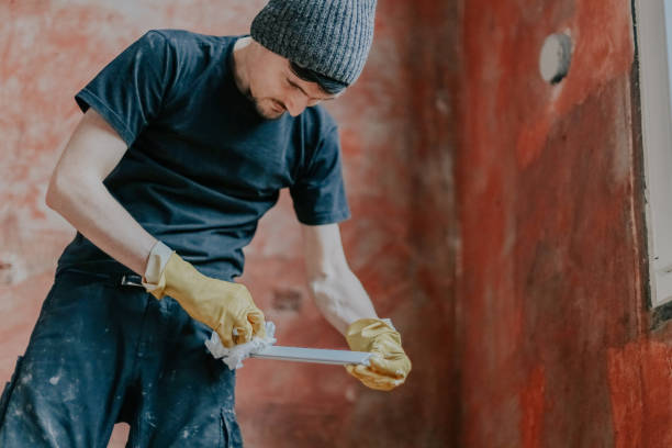 istock A young man washes window frames with a paper napkin. 2167472345