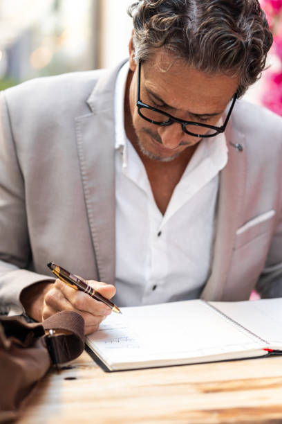 Close-up of a Caucasian female hand holding a fountain pen and signing a purchase contract written in Czech language. Concept for old law, legal issues and old handwritten documents.