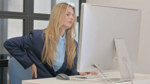 istock Young Businesswoman with Spinal Injury Working on Desktop 2167473677