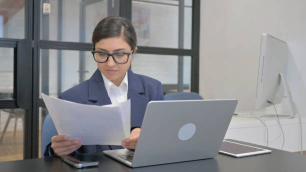 istock Papaerwork by Indian Businesswoman Using Laptop 2167474895
