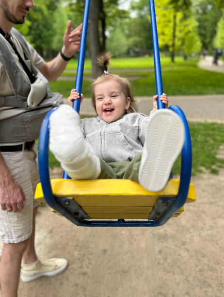 istock Father Swinging Child with Cast in Park 2167485562