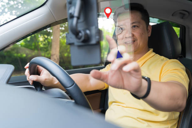 Close-up on a couple using the GPS while driving a car. Driver using GPS navigation in mobile phone while driving car at sunset. Man using mobile phone in car