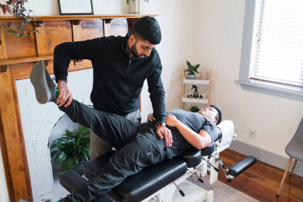 istock A chiropractor stretches  the male patient legs. 2167495520
