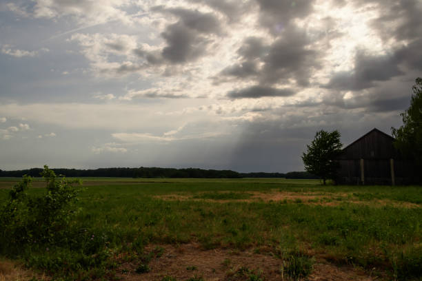 Dark clouds hovering over an old barn in the countryside, the calm before the storm,