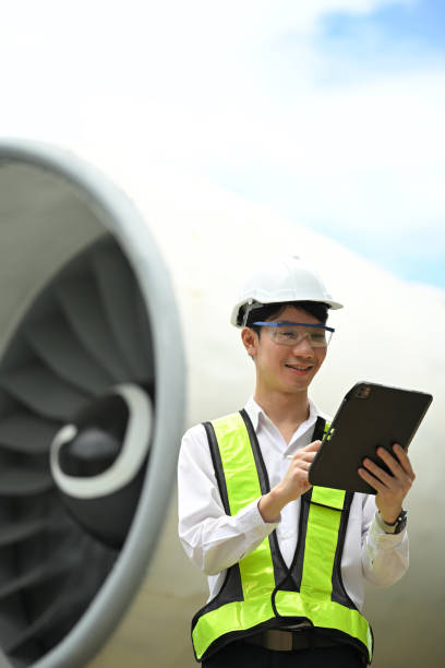 istock Portrait of aviation engineer using digital tablet in front of a large airplane engine 2167511453