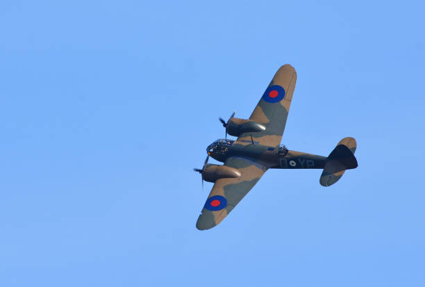 Avro Lancaster heavy bomber, Bournemouth, England. This four-engine bomber aircraft in flight over open sea with cumulus cloud formation in blue sky was the mainstay of bomber command in WW2