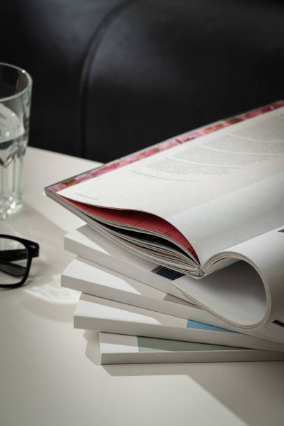 istock Stack of White Paperbacks and Glass of Water on White Table 2167512237