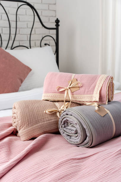 istock Rolled Up Soft Pink and Grey Muslin Blankets on Bed 2167512920