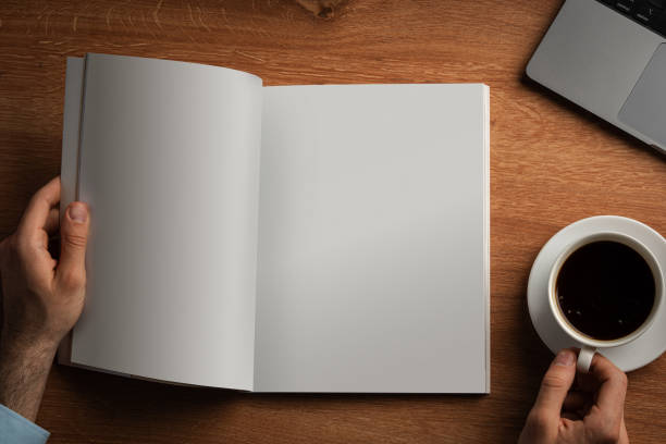 istock Man Reading Page of Magazine While Holding Coffee Cup 2167513550