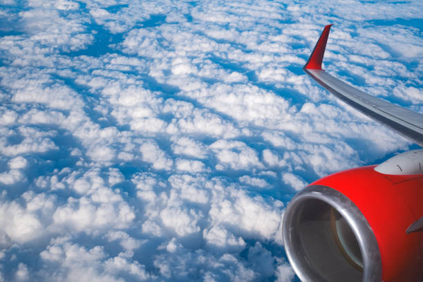 View of clouds and wing from a plane window. Travel and vacations concept