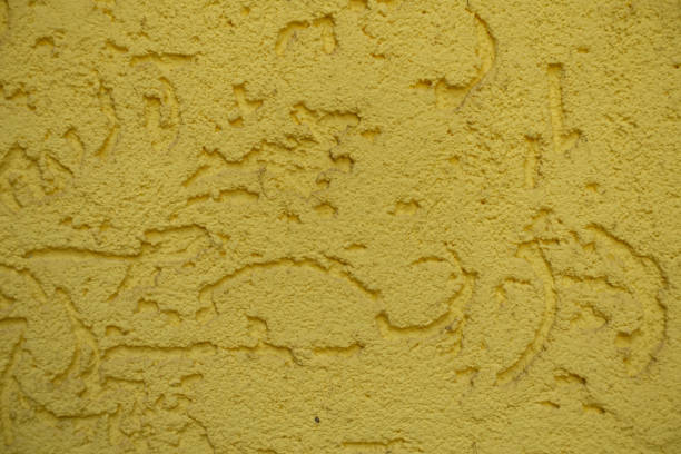 Macro of yellow wall with stucco worm finish