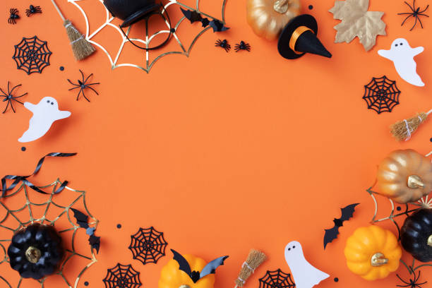 istock Halloween holiday frame with party decorations from pumpkins, bats, spider web and ghosts top view. Happy halloween greeting card on orange. 2167515832