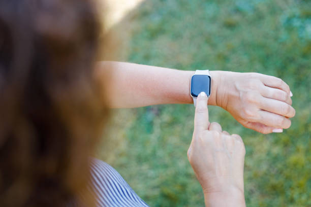 Woman in the park using her smart-watch app