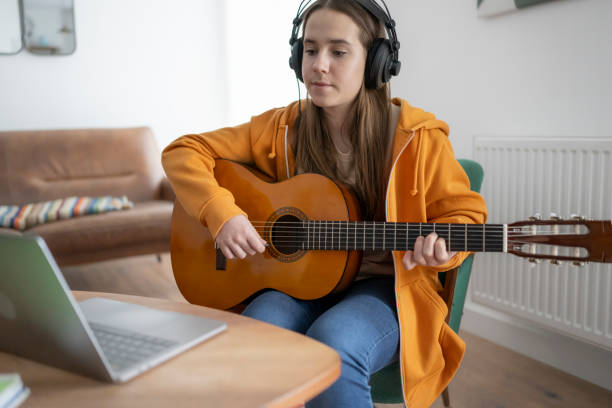 istock Young Woman Learning Guitar Online 2167525988