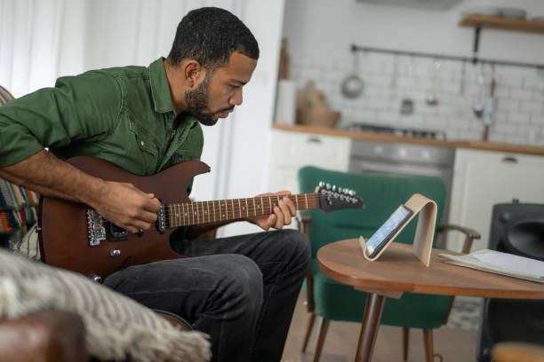 istock Man learning to play guitar with tablet 2167526490