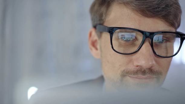 istock Businessman with glasses looking intently obscured partially by a translucent surface of laptop. Business people concept 2167531916