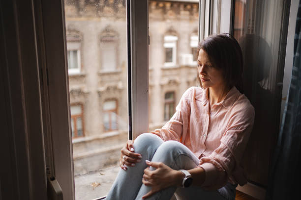 istock A woman sits by the window in Budapest, reflecting on her thoughts during a quiet afternoon 2167532059