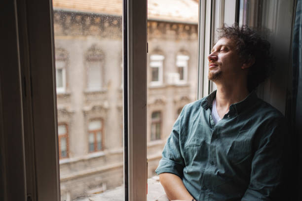 istock A man relaxes by the window while enjoying a quiet afternoon in Budapest, surrounded by historic architecture 2167532140