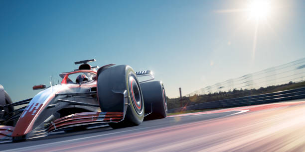 Racing drivers driving red and yellow open-wheel single-seater racing car cars on racing track.