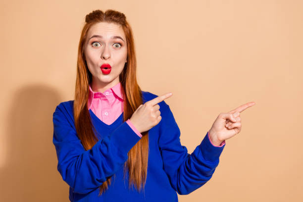 istock Photo of shocked attractive lady dressed blue pullover pointing fingers empty space isolated beige color background 2167533003