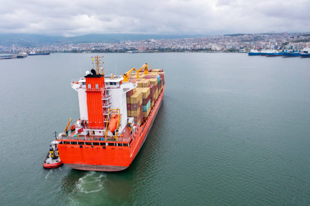 istock Aerial view of Cargo container ship carrying container and running with tugboat for import goods to cargo container terminal for customs. Concept of logistics transportation and shipping. 2167533653