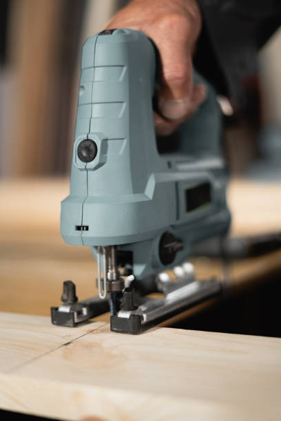 istock man cutting a wooden plank with electric jigsaw in a workshop 2167535200