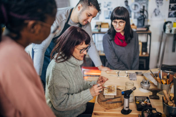 istock Instructor meticulously demonstrates jewelry making technique. 2167538006