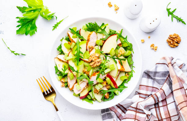 istock Old fashioned salad with chicken, red and green apples, raw celery, lettuce and walnuts, white background, top view 2167538118