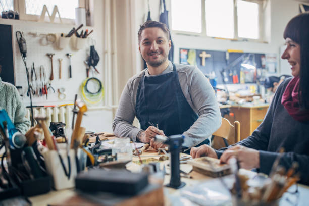 istock Man in apron smiling in workshop at wooden table 2167538701