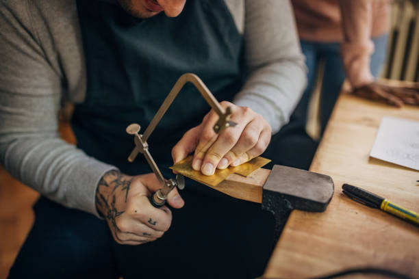 istock Close-up of hands using a saw in woodworking class 2167539766
