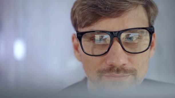 istock Businessman with glasses looking intently obscured partially by a translucent surface of laptop. Business concept 2167543366