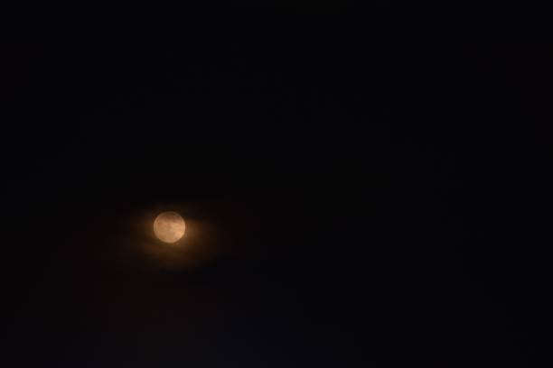 istock yellow full moon covering by cloud floating on sky in night 2167544422