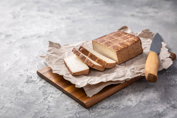 istock Organic smoked tofu on kitchen table with knife 2167547428