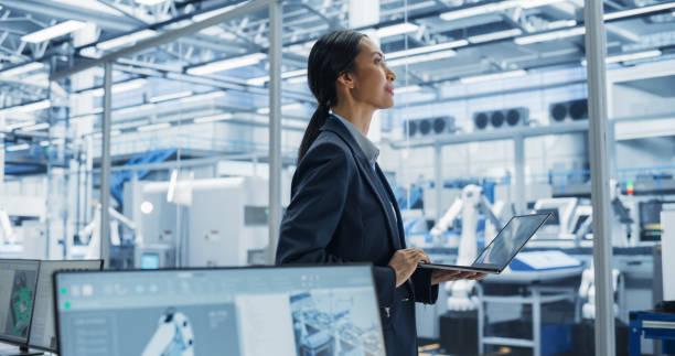 istock Close Up Of Electronics Manufacturing Technician Working on a Laptop Computer at a Factory Space. Asian Female Specialist Developing, Maintaining, and Fine-Tuning Programs for Production and Assembly. 2167548479