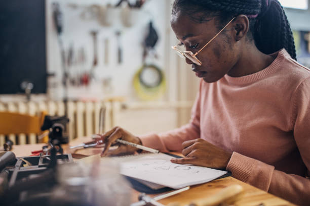 istock Young girl drawing designs at a wooden workspace 2167548500