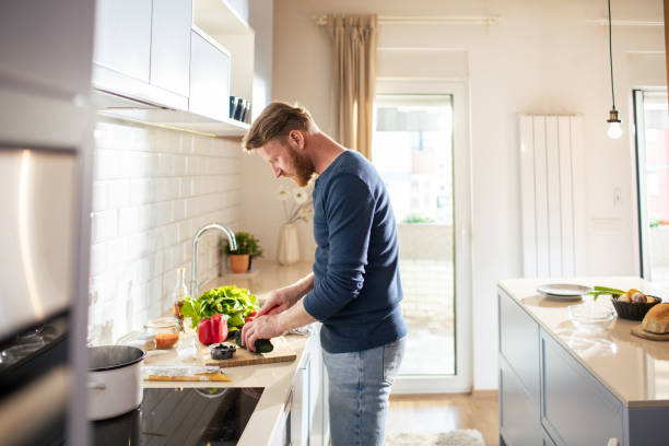 istock Young man preparing vegetables for lunch in the kitchen at home 2167551276