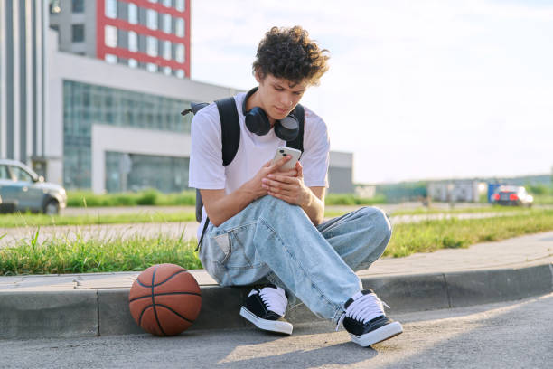 istock Young guy using smartphone, modern city street background 2167551537