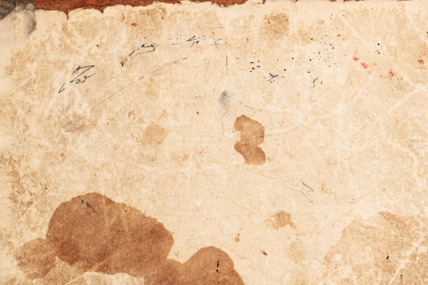 istock Aged sheet of parchment displaying faded ink marks and various stains, 2167551847