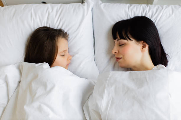 istock Mother and daughter sleeping peacefully in bed 2167552123