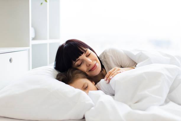 istock Mother and child sleeping peacefully in white bed 2167552153