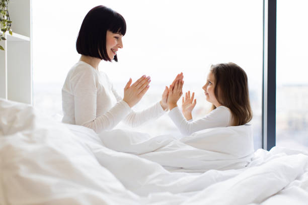 istock Mother and daughter playing and bonding in bed together 2167552202
