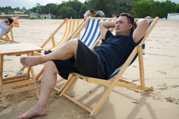 Male tourist sitting on beach chair